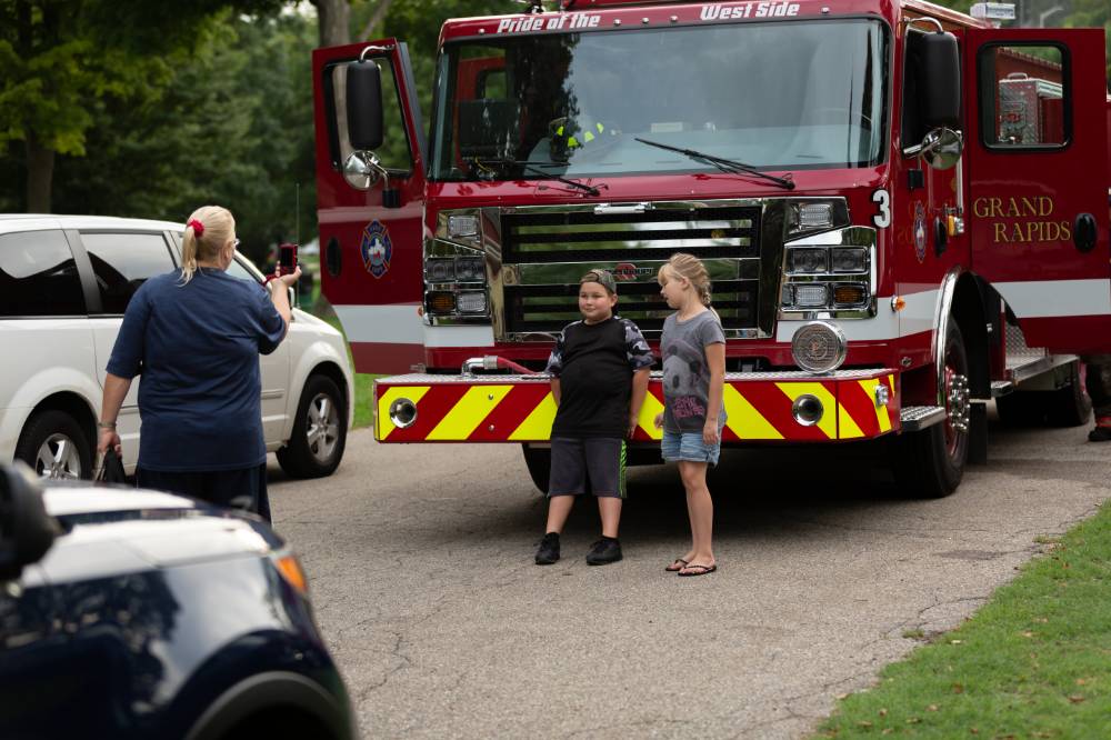 young boy and girl posing in front of a firetruck